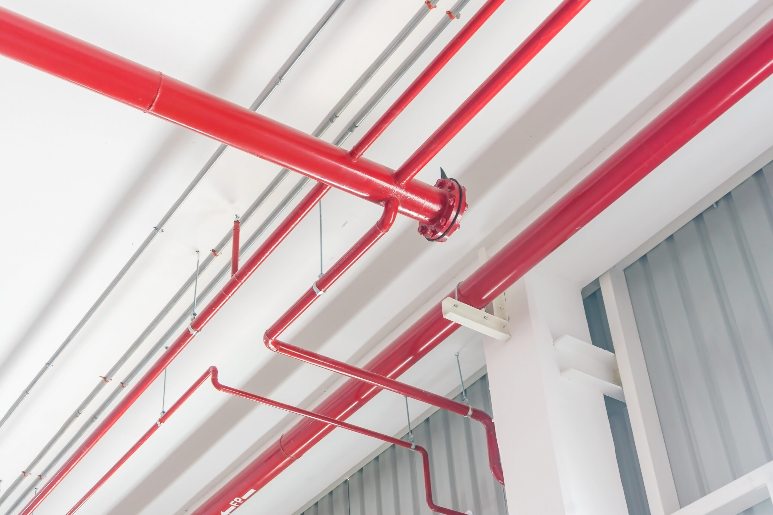 red pipeline extinguishing water in industrial building